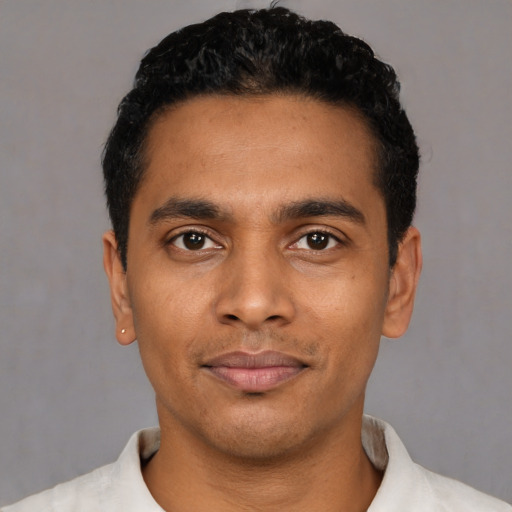 Joyful latino young-adult male with short  black hair and brown eyes