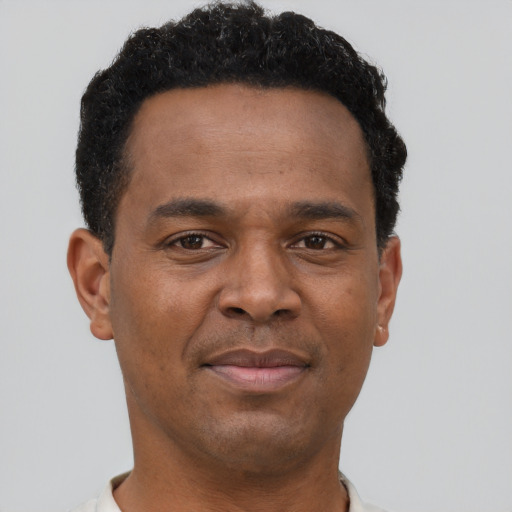 Joyful black young-adult male with short  brown hair and brown eyes