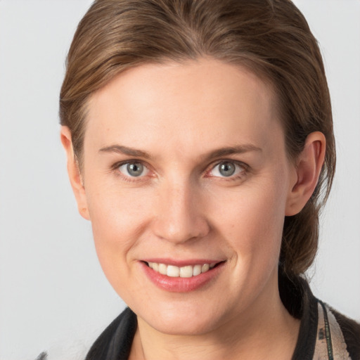 Joyful white young-adult female with medium  brown hair and grey eyes