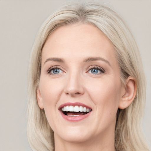 Joyful white young-adult female with long  brown hair and blue eyes