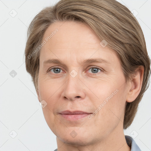 Joyful white adult female with medium  brown hair and grey eyes