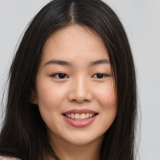 Joyful asian young-adult female with long  brown hair and brown eyes