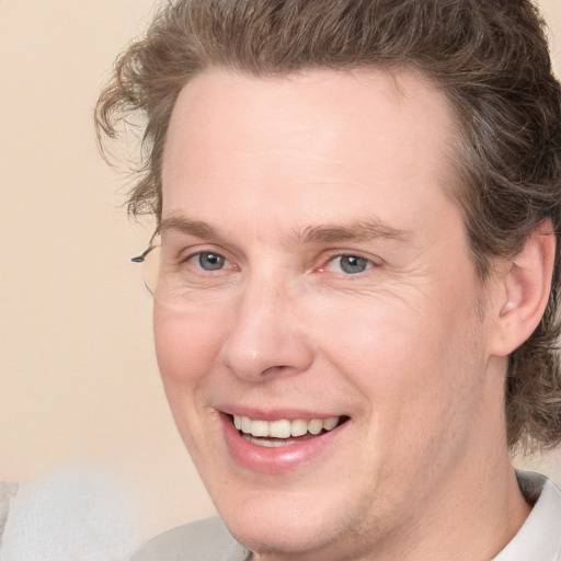 Joyful white adult male with short  brown hair and grey eyes