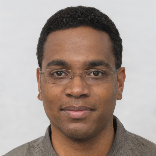 Joyful black young-adult male with short  black hair and brown eyes