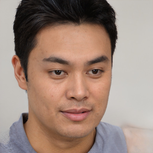 Joyful asian young-adult male with short  brown hair and brown eyes