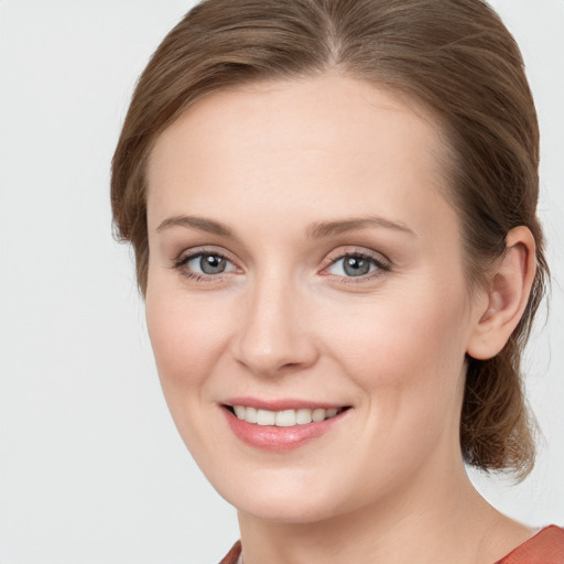 Joyful white young-adult female with medium  brown hair and blue eyes