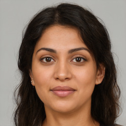 Joyful latino young-adult female with long  brown hair and brown eyes