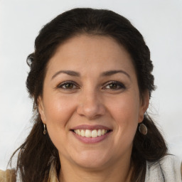 Joyful white adult female with long  brown hair and brown eyes