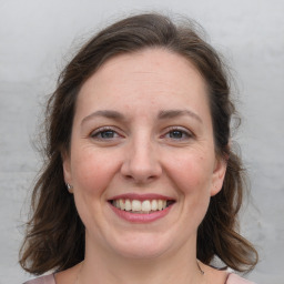 Joyful white adult female with medium  brown hair and grey eyes