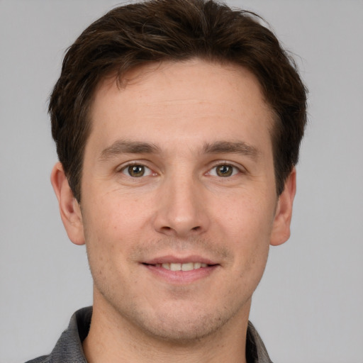 Joyful white young-adult male with short  brown hair and grey eyes