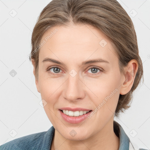 Joyful white adult female with medium  brown hair and grey eyes