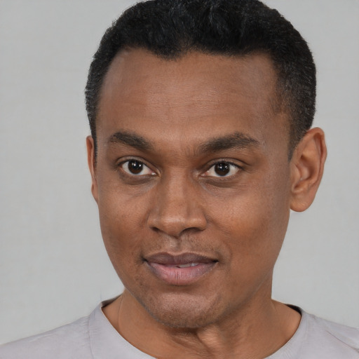 Joyful black young-adult male with short  black hair and brown eyes