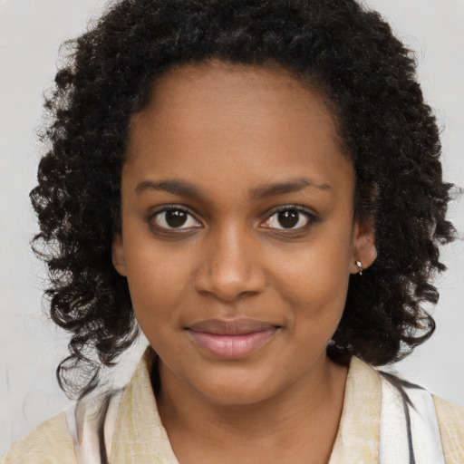Joyful black young-adult female with long  brown hair and brown eyes