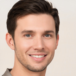 Joyful white young-adult male with short  brown hair and grey eyes