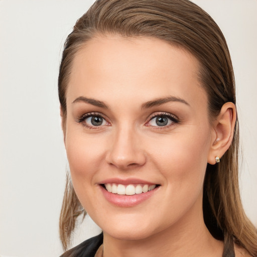 Joyful white young-adult female with long  brown hair and blue eyes