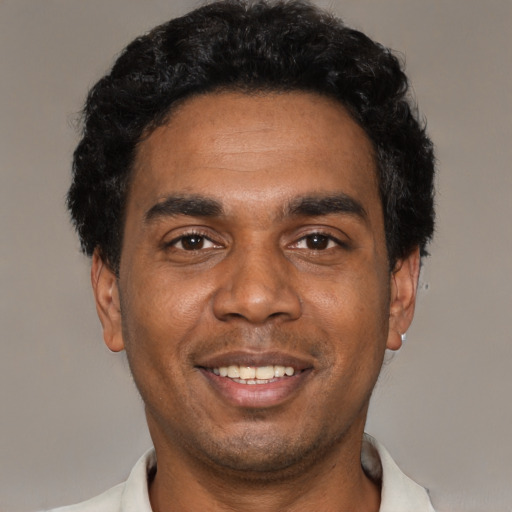 Joyful black young-adult male with short  black hair and brown eyes