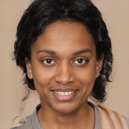 Joyful black young-adult female with long  black hair and brown eyes