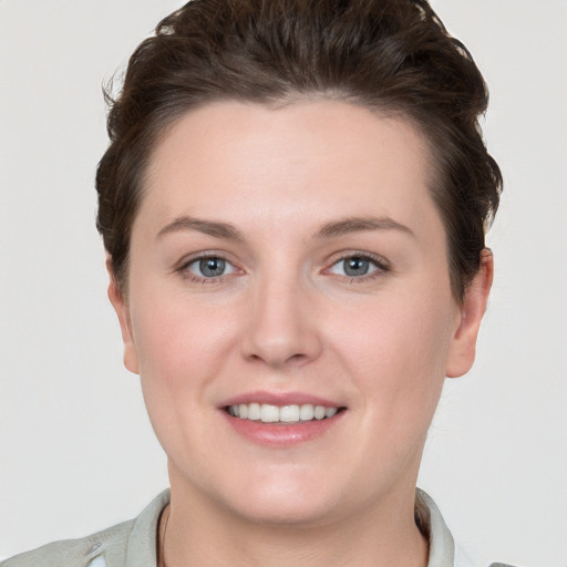 Joyful white young-adult female with short  brown hair and grey eyes