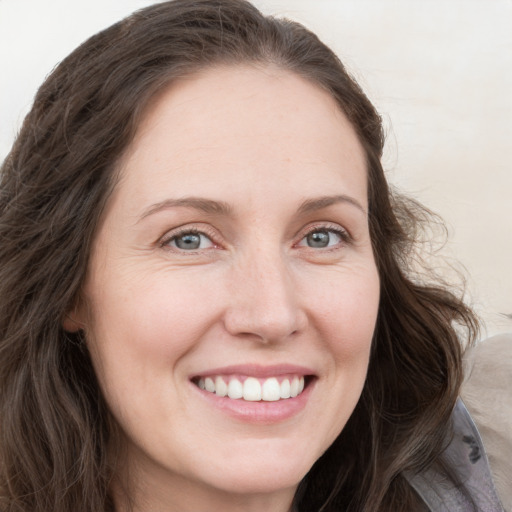 Joyful white young-adult female with long  brown hair and blue eyes