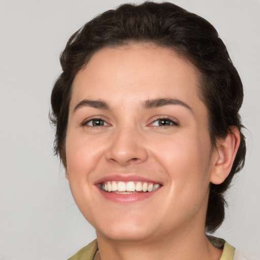 Joyful white young-adult female with medium  brown hair and green eyes