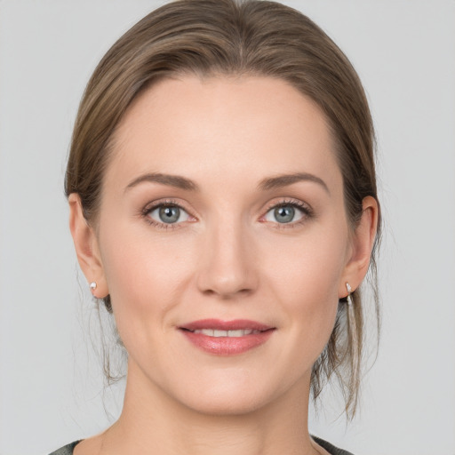 Joyful white young-adult female with medium  brown hair and grey eyes