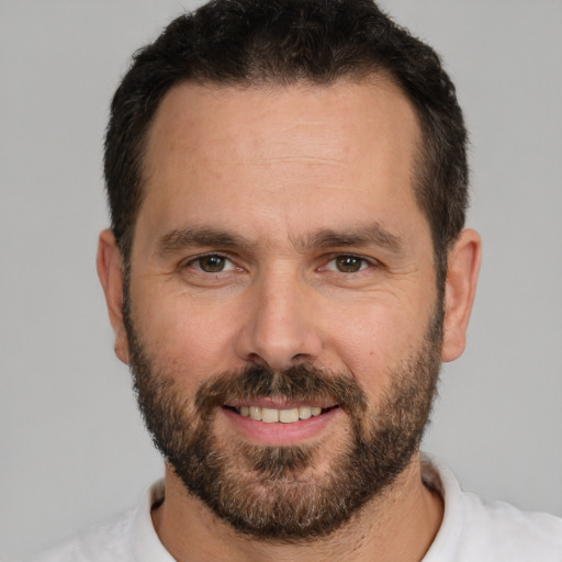 Joyful white adult male with short  black hair and brown eyes