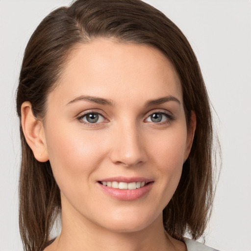 Joyful white young-adult female with medium  brown hair and grey eyes