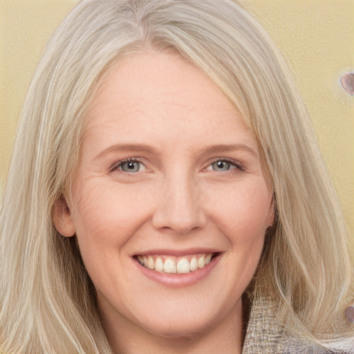 Joyful white young-adult female with long  blond hair and grey eyes