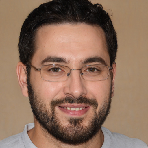 Joyful white adult male with short  black hair and brown eyes