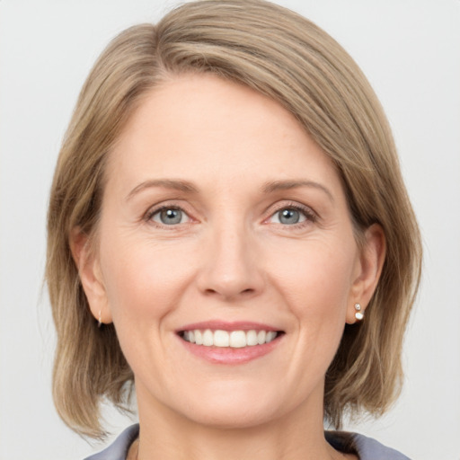 Joyful white adult female with medium  brown hair and grey eyes