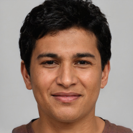 Joyful white young-adult male with short  black hair and brown eyes