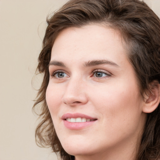 Joyful white young-adult female with medium  brown hair and green eyes