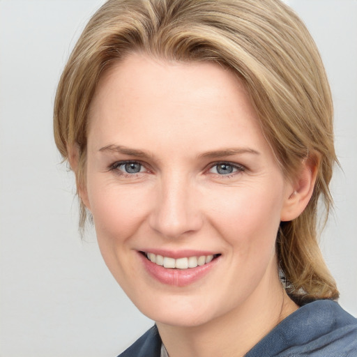 Joyful white young-adult female with medium  brown hair and blue eyes