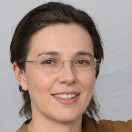 Joyful white adult female with medium  brown hair and brown eyes