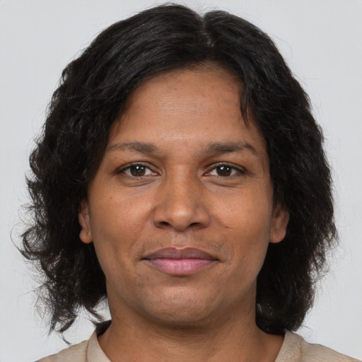 Joyful black adult female with medium  brown hair and brown eyes