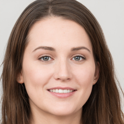 Joyful white young-adult female with long  brown hair and grey eyes