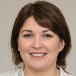 Joyful white adult female with medium  brown hair and brown eyes