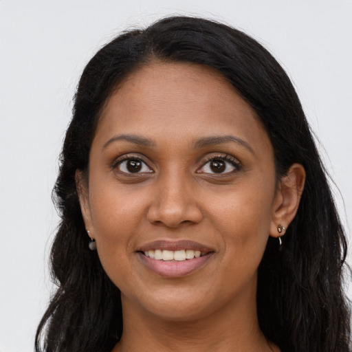 Joyful black young-adult female with long  brown hair and brown eyes