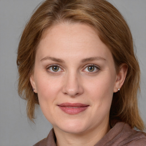 Joyful white young-adult female with medium  brown hair and blue eyes