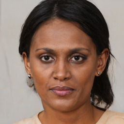 Joyful black adult female with medium  brown hair and brown eyes