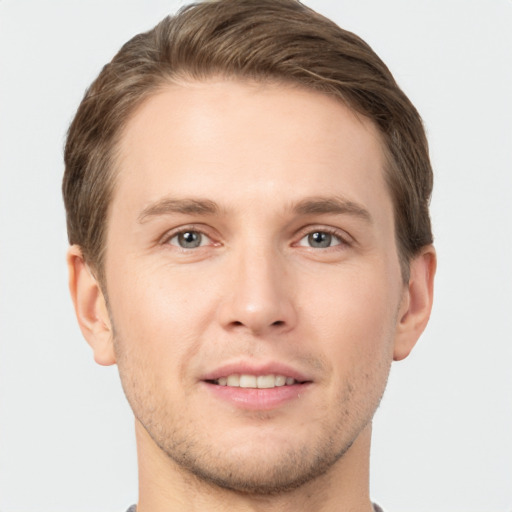 Joyful white young-adult male with short  brown hair and grey eyes