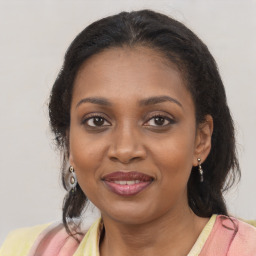 Joyful black young-adult female with long  brown hair and brown eyes