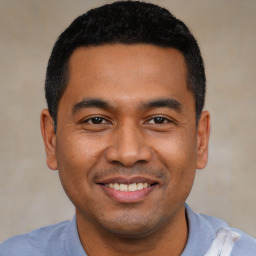 Joyful latino young-adult male with short  black hair and brown eyes