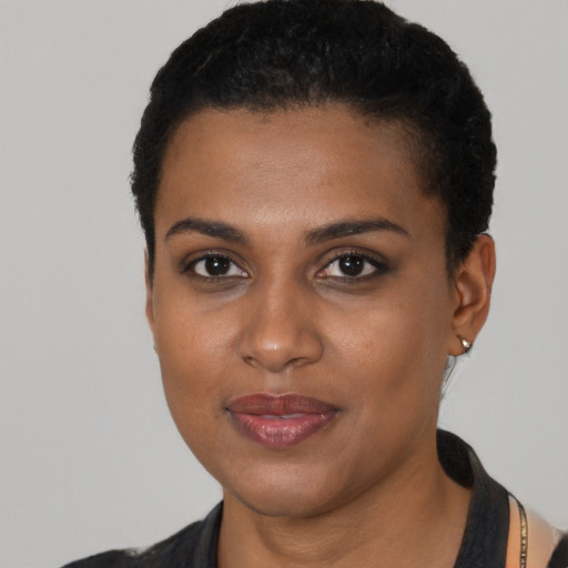 Joyful black young-adult female with short  black hair and brown eyes