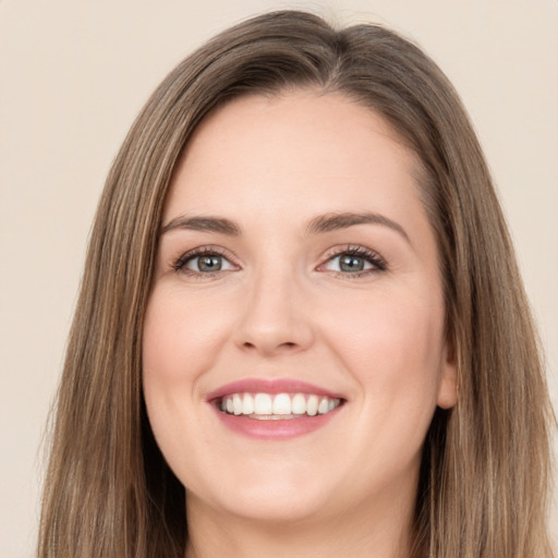 Joyful white young-adult female with long  brown hair and green eyes