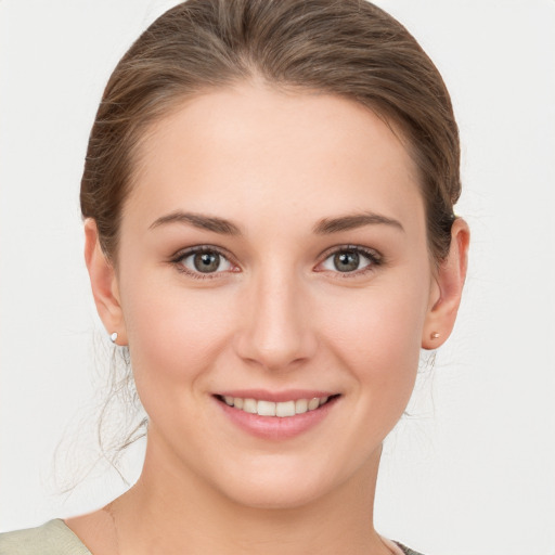 Joyful white young-adult female with medium  brown hair and grey eyes