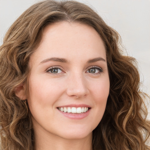 Joyful white young-adult female with long  brown hair and green eyes