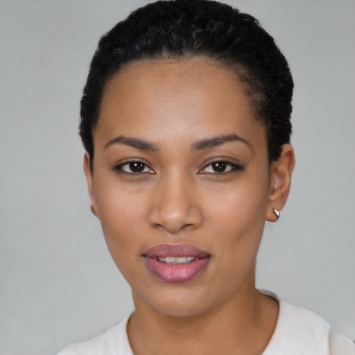 Joyful black young-adult female with short  black hair and brown eyes