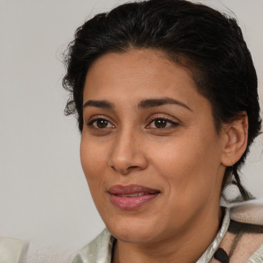 Joyful latino adult female with medium  brown hair and brown eyes