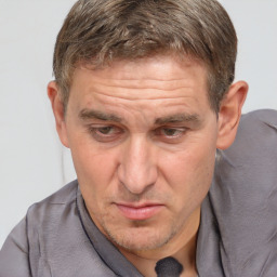 Joyful white middle-aged male with short  brown hair and brown eyes